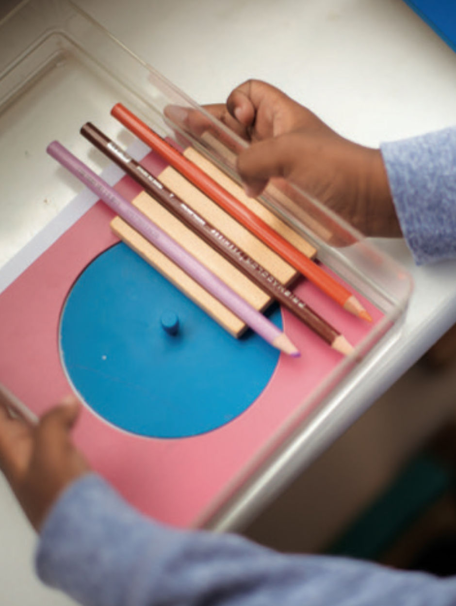 child handling colored pencil box